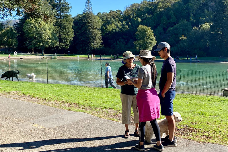 3 people talking with Spring Lake Lagoon in the background