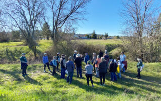 Group of people gathered outdoors on the Southeast Greenway property for a tour.