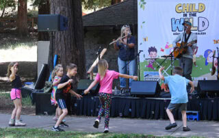 Children dancing in front of a band at Child in the Wild