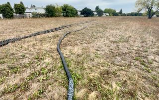 Well testing on the greenway with photo of black water piping running along length of greenway property