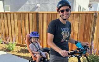 Photo of Dan Hennessey and daughter on bike with helmets. New City Leadership for SEG