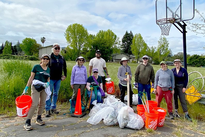 Group of volunteers cleaning up Southeast Greenway property in the spring