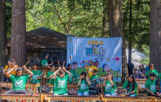 Child in the Wild sign with kids musical group in the foreground
