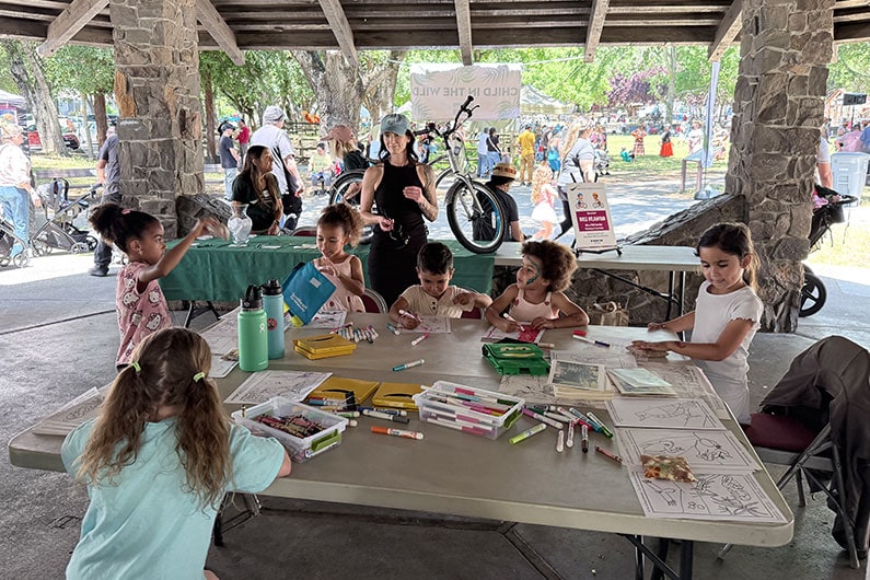 Children coloring at the Southeast Greenway tent at Child in the Wild