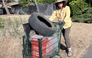 volunteer pushing a shopping cart of trash